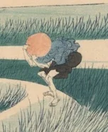 笠を押さえる旅人