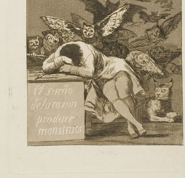 机に突っ伏して眠る男